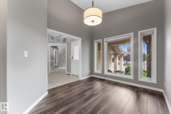 Vaulted ceiling with drum pendant lighting, wood-finish flooring, and multiple windows - 