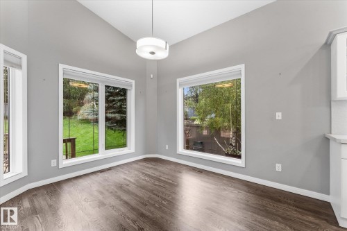 Vaulted ceilings with a pendant light fixture, wood-finish flooring, and multiple windows with white trim - 8 Osborne Close, St. Albert, AB - Indoor Photo Showing Other Room