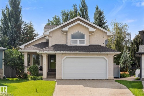 Stucco exterior with a peaked roofline, attached two-car garage, covered porch entry, and a prominent arched window on the upper level - 8 Osborne Close, St. Albert, AB - Outdoor
