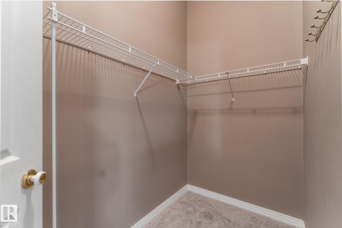 Corner walk-in closet featuring white wire shelving and a wall-mounted coat rack - 8 Osborne Close, St. Albert, AB - Indoor With Storage