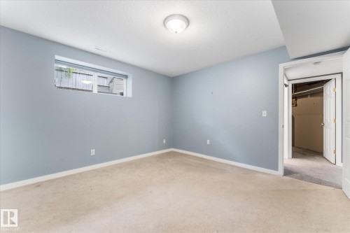 Recessed window, neutral carpeting, light blue wall paint, white trim, and overhead lighting - 8 Osborne Close, St. Albert, AB - Indoor Photo Showing Other Room