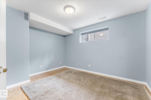 Recessed window with horizontal blinds, overhead flush mount lighting, and light-toned wall paint - 8 Osborne Close, St. Albert, AB - Indoor Photo Showing Other Room