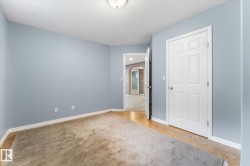 White six-panel interior door with chrome hardware, pale blue wall paint, and recessed ceiling lighting - 