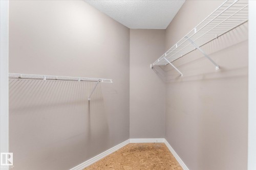 Recessed closet space featuring wire shelving and wood-finish flooring - 8 Osborne Close, St. Albert, AB - Indoor With Storage