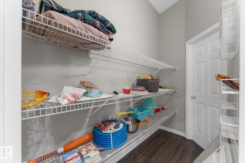 Expansive storage area featuring multiple tiers of wire shelving, dark wood-finish flooring, and a paneled interior door - 8 Osborne Close, St. Albert, AB - Indoor With Storage