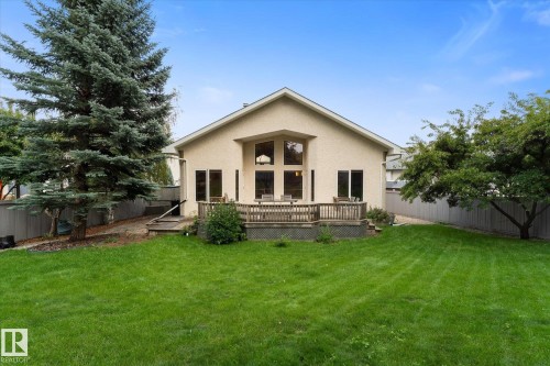 Expansive lawn with mature trees, a multi-level wood deck, and a stucco exterior - 8 Osborne Close, St. Albert, AB - Outdoor