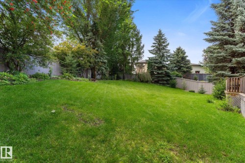Expansive backyard featuring a lush lawn, mature trees, and privacy fencing - 8 Osborne Close, St. Albert, AB - Outdoor