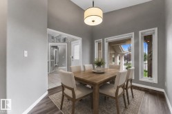 Vaulted ceiling with a drum pendant light fixture, wood-finish flooring, and multiple windows - 