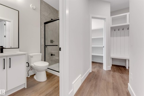 Full bathroom featuring a white vanity with black hardware, black-framed mirror, and a walk-in shower with grey tile surround and black-framed glass enclosure - 329 Balsam Link, Leduc, AB - Indoor Photo Showing Bathroom