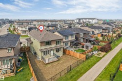 Two-story residence featuring a wood deck, fenced backyard, and a paved pathway bordering the property - 