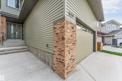 Exterior featuring light green horizontal siding and stacked stone accents - 