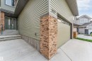 Exterior featuring light green horizontal siding and stacked stone accents - 329 Balsam Link, Leduc, AB  - Outdoor 