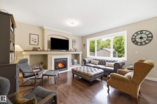 Hardwood flooring, recessed lighting, built-in fireplace, crown molding, and a large window - 2416 Warry Place Sw, Edmonton, AB - Indoor Photo Showing Living Room With Fireplace