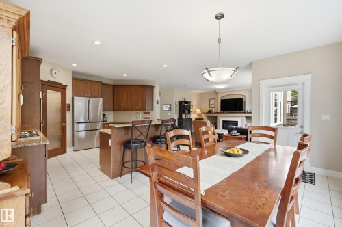 Kitchen featuring wood cabinetry, stainless steel refrigerator, and granite countertops - 2416 Warry Place Sw, Edmonton, AB - Indoor Photo Showing Other Room