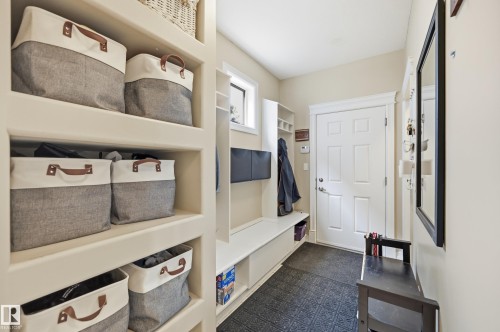 Built-in shelving, white paneled door, and built-in bench seating - 2416 Warry Place Sw, Edmonton, AB - Indoor Photo Showing Other Room
