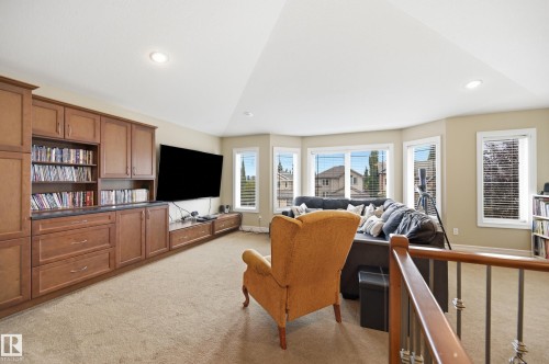 Built-in entertainment center with extensive cabinetry and shelving, bay window configuration, recessed lighting, and carpet flooring - 2416 Warry Place Sw, Edmonton, AB - Indoor
