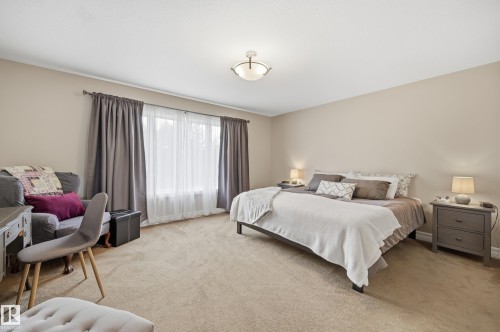 Neutral wall color, wall-to-wall carpeting, window with drapery, and a ceiling-mounted light fixture - 2416 Warry Place Sw, Edmonton, AB - Indoor Photo Showing Bedroom