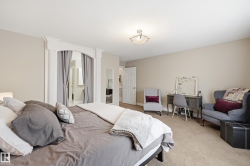 Recessed ceiling lighting, neutral wall paint, arched doorway with decorative trim, carpet flooring, and a flush mount ceiling fixture - 2416 Warry Place Sw, Edmonton, AB - Indoor Photo Showing Bedroom