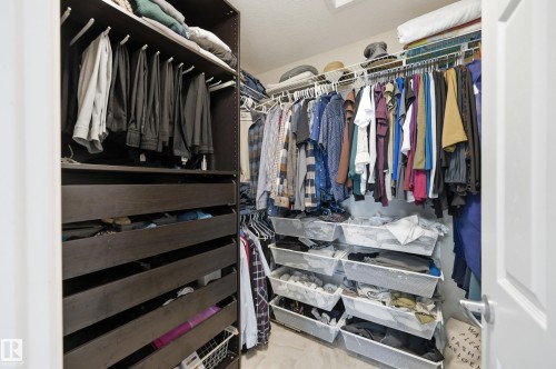 Built-in closet system with dark wood-finish drawers, white wire shelving, and overhead storage - 2416 Warry Place Sw, Edmonton, AB - Indoor With Storage