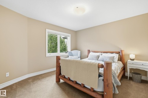 Recessed window with white trim, tan wall paint, ceiling-mounted light fixture, and textured carpeting - 2416 Warry Place Sw, Edmonton, AB - Indoor Photo Showing Bedroom