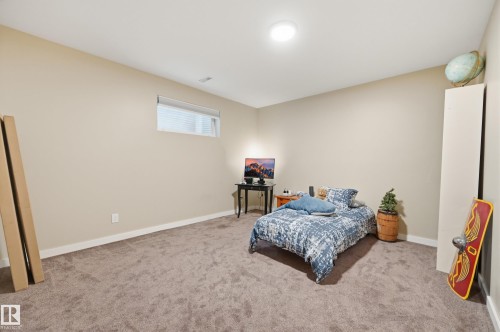 Recessed ceiling lighting illuminates a room featuring a rectangular window, light neutral wall paint, and textured carpeting - 2416 Warry Place Sw, Edmonton, AB - Indoor Photo Showing Bedroom