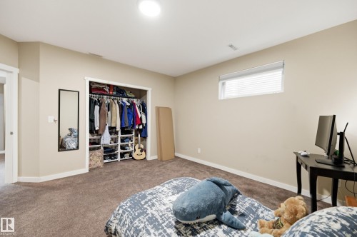 Recessed ceiling lighting, a window with horizontal blinds, and a built-in closet system with shelving and hanging rods - 2416 Warry Place Sw, Edmonton, AB - Indoor