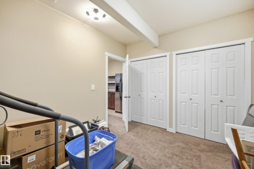 Two bi-fold closet doors, carpeted flooring, and a flush mount light fixture - 2416 Warry Place Sw, Edmonton, AB - Indoor