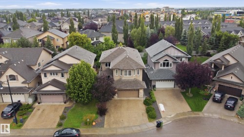 Residential neighborhood setting with varied architectural styles, mature landscaping, and private driveways - 2416 Warry Place Sw, Edmonton, AB - Outdoor With Facade