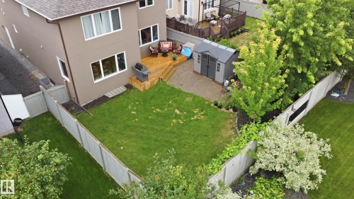 Spacious backyard oasis featuring a manicured lawn bordered by mature landscaping and privacy fencing - 2416 Warry Place Sw, Edmonton, AB - Outdoor
