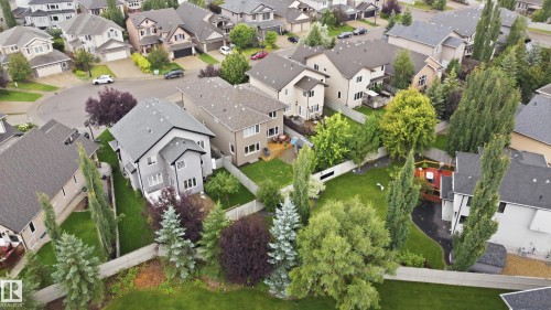 Residential property featuring a grey exterior, a dark grey shingle roof, and a private backyard with mature landscaping - 2416 Warry Place Sw, Edmonton, AB - Outdoor With View