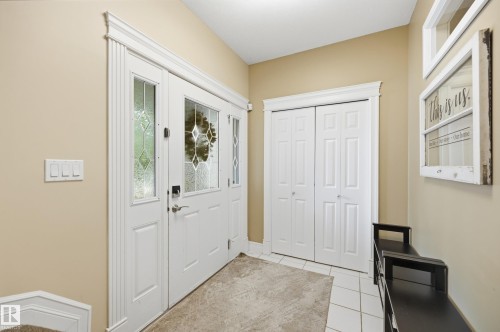 Entryway featuring a decorative glass paneled door, sidelights, and a white bi-fold closet - 2416 Warry Place Sw, Edmonton, AB - Indoor Photo Showing Other Room