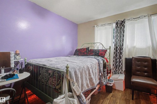 Wood-finish flooring with multiple windows and light-toned walls - 5724 143 Avenue Nw, Edmonton, AB - Indoor Photo Showing Bedroom
