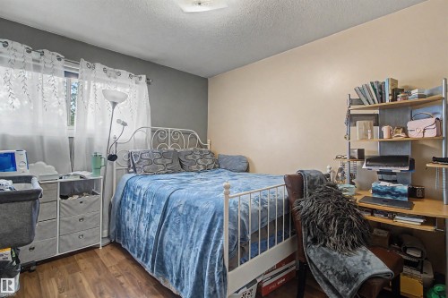 Wood-finish flooring with a two-tone wall treatment - 5724 143 Avenue Nw, Edmonton, AB - Indoor Photo Showing Bedroom