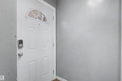 White panel door with an arched transom window and digital entry lock - 