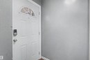 White panel door with an arched transom window and digital entry lock - 5724 143 Avenue Nw, Edmonton, AB 