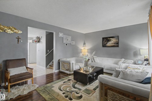 Wood-finish flooring with a decorative area rug - 5724 143 Avenue Nw, Edmonton, AB - Indoor Photo Showing Living Room