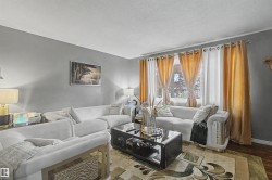 Room featuring neutral wall tones, multiple windows with rod-pocket curtains, and wood-finish flooring - 