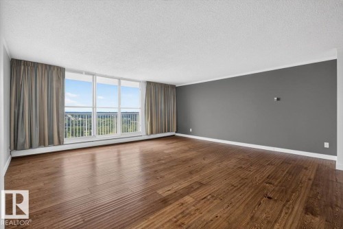 Expansive room with wood-finish flooring, a full wall of windows, and a neutral color palette - #506 12121 Jasper Av Nw, Edmonton, AB - Indoor Photo Showing Other Room