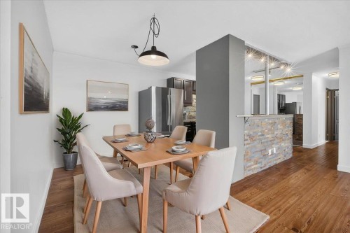 Wood-finish flooring, recessed lighting, and a stone-clad half-wall feature - #506 12121 Jasper Av Nw, Edmonton, AB - Indoor Photo Showing Dining Room