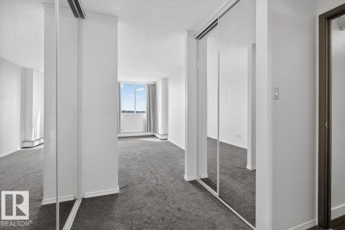 Wall-to-wall carpeting and mirrored closet doors - #506 12121 Jasper Av Nw, Edmonton, AB - Indoor Photo Showing Other Room