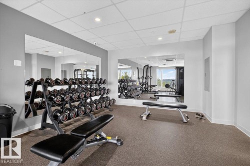 Wall-to-wall mirrors, recessed lighting, drop-tile ceiling, and rubberized flooring - #506 12121 Jasper Av Nw, Edmonton, AB - Indoor Photo Showing Gym Room