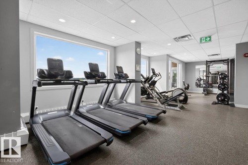 Fitness facility with a large exterior window, recessed lighting, and resilient flooring - #506 12121 Jasper Av Nw, Edmonton, AB - Indoor Photo Showing Gym Room