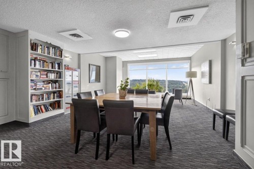 Built-in shelving, expansive windows, recessed lighting, wall-mounted sconces, and patterned carpet - #506 12121 Jasper Av Nw, Edmonton, AB - Indoor Photo Showing Dining Room
