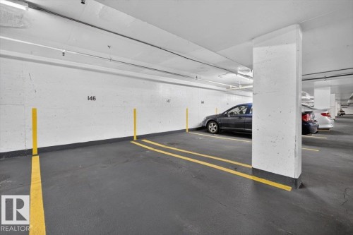 Designated parking space with painted floor markings and concrete pillars - #506 12121 Jasper Av Nw, Edmonton, AB - Indoor Photo Showing Garage
