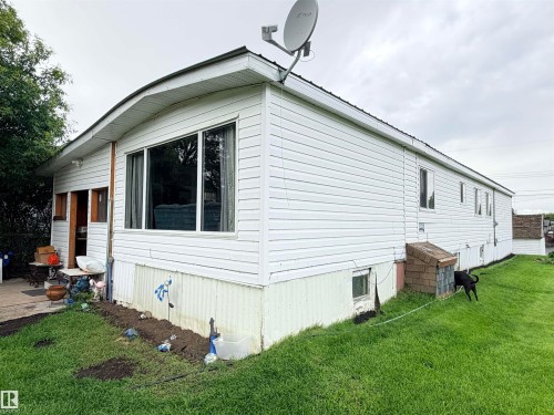 White vinyl siding exterior with large front window and satellite dish - 9940 110 Street, Westlock, AB - Outdoor With Exterior