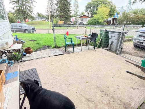 Concrete patio surface with a chain link fence and a grassy area - 9940 110 Street, Westlock, AB - Outdoor