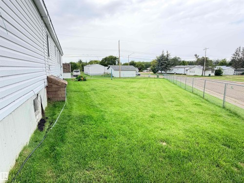 Expansive grass lawn with chain link perimeter fencing - 9940 110 Street, Westlock, AB - Outdoor