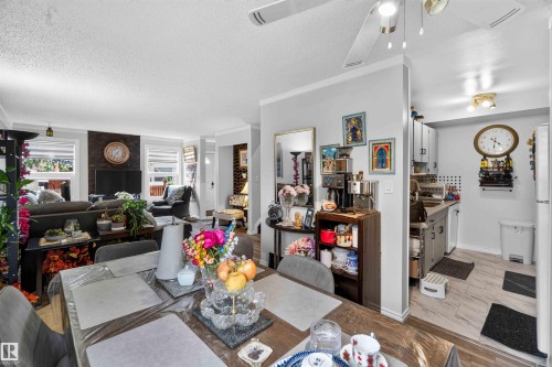 Dining area opening to the living space, featuring a ceiling fan, crown molding, and recessed lighting - 17127 109 Street Nw, Edmonton, AB - Indoor Photo Showing Dining Room