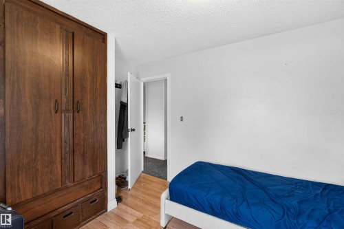 Wood-finish flooring with a contrasting white wall - 17127 109 Street Nw, Edmonton, AB - Indoor Photo Showing Bedroom
