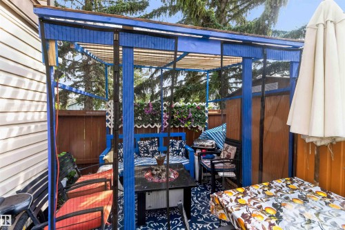 Blue-framed pergola with a slatted roof, providing an outdoor living area - 17127 109 Street Nw, Edmonton, AB - Outdoor